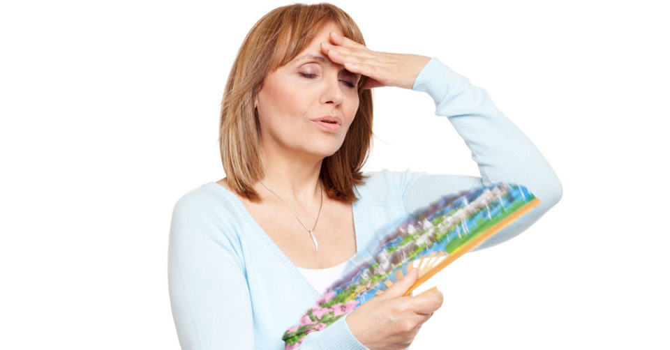 A woman having hot flashes, holding her forehead