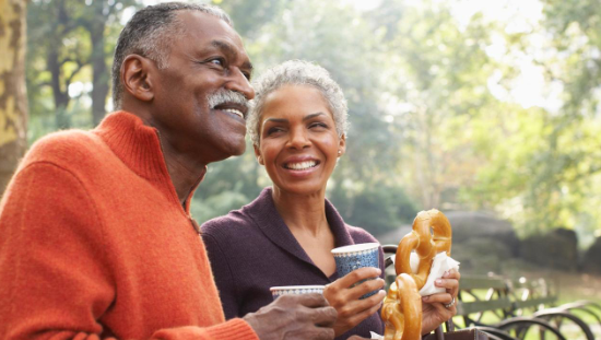 African American couple smiling with beverages and soft pretzels