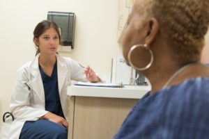 white female medical professional consulting with an African American woman in a medical office