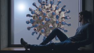 man looking out the window at a giant COVID-19 virus